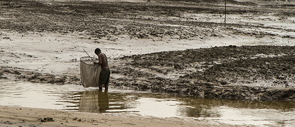 Nigerian boy fishing in polluted waters