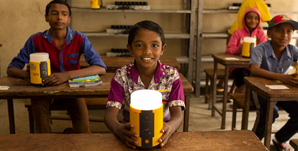 Child with solar energy lamp in a school in Bangladesh.