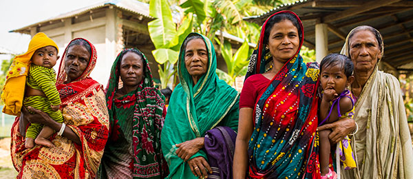 Group of five Bangladeshi women with two children in colourful clothing.
